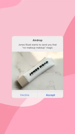 White AirDrop notification on a soft pink wavy background containing a flat-lay photo of a Jones Road cosmetic tube on marble