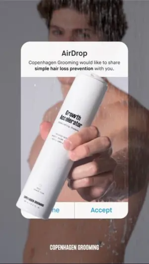 Man in a shower holding a white shampoo bottle, with a white iOS AirDrop notification box overlaid in the center